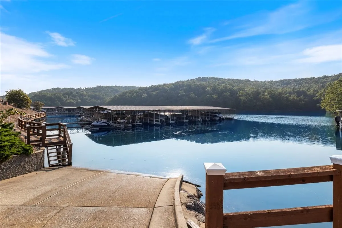 A tranquil marina with calm water, surrounded by lush hills. The serene scene hints at activities like boating, fishing, or simply enjoying a sunset by the shore, all within easy reach from the property.
